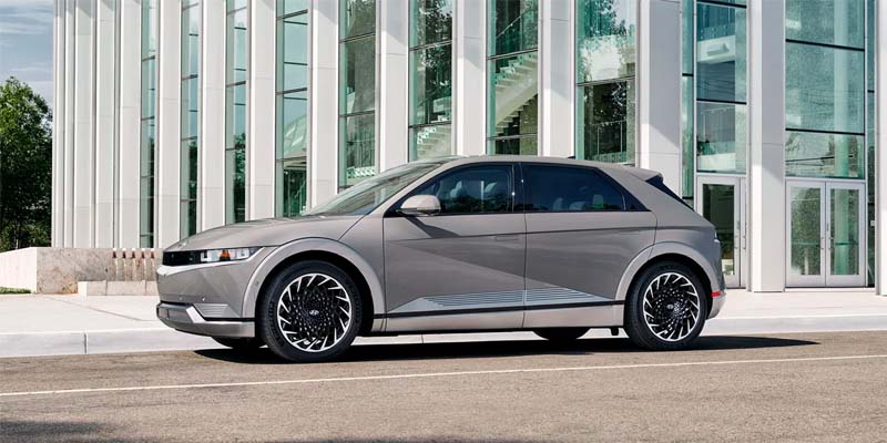 Gray Hyundai Ioniq parked in a parking lot next a big building on a sunny day