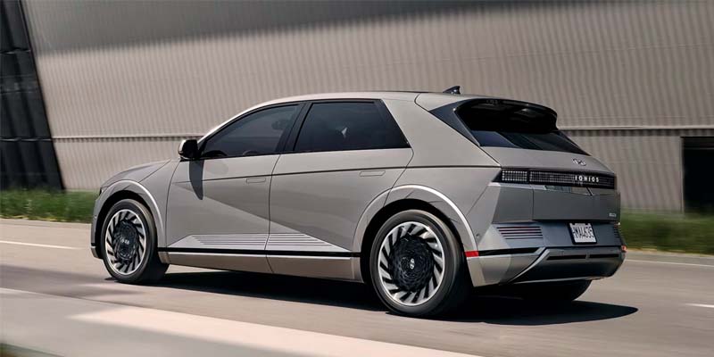 Gray Hyundai Ioniq driving down the road at high speed during the day